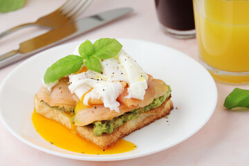 Breakfast with a sandwich with poached egg and avocado