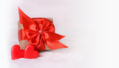 Valentine's Day background. Gift box with a red bow and two hearts on a white background. Valentines day concept.Copy space.