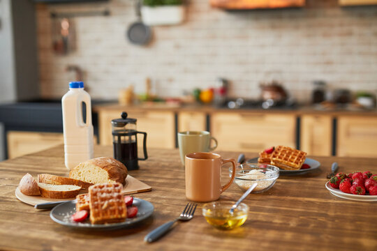 Background image of sweet breakfast waffles with strawberry on wooden table in cozy kitchen, copy space