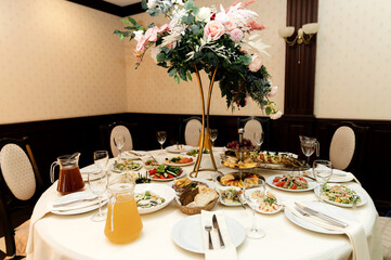 wedding banquet. flowers and food are on the festive table. empty festive table in the restaurant.