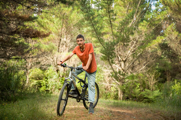 Obraz premium happy teen boy riding a bike on natural background, forest or park. healthy lifestyle, family day out