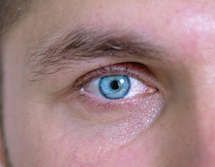 Obraz premium Man with blue eyes and a corrective contact lens.