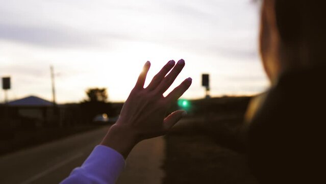 Silhouette hand of happy girl at sunset. Hand in the sun close-up sunlight dream concept.