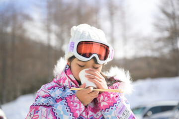 スキー場のゲレンデで雪遊びする小学生の女の子
