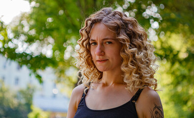 Naklejka premium Portrait of curly-haired woman on the street