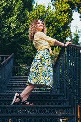 Beautiful woman in a yellow shirt on the stairs