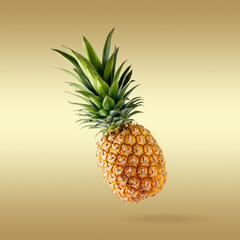 Fresh juicy tropical fruit pineapple flying on gradient golden background.
