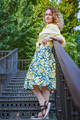 Beautiful woman in a yellow shirt on the stairs