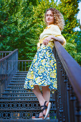 Beautiful woman in a yellow shirt on the stairs