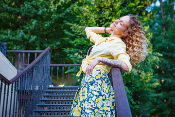 Beautiful woman in a yellow shirt on the stairs