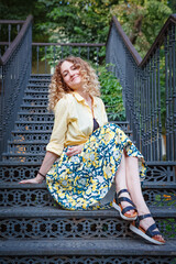 Beautiful woman in a yellow shirt on the stairs