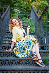 Beautiful woman in a yellow shirt on the stairs