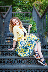 Beautiful woman in a yellow shirt on the stairs