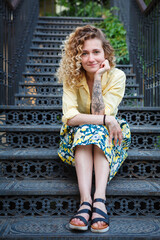 Beautiful woman in a yellow shirt on the stairs
