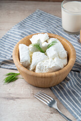 Traditional homemade salted cottage cheese cheese in a wooden bowl