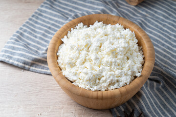 Fototapeta na wymiar Traditional homemade cottage cheese in a wooden bowl