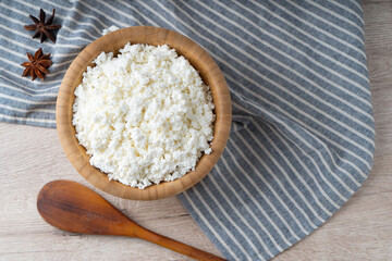 Traditional homemade cottage cheese in a wooden bowl