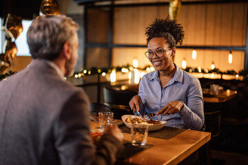 Confident adult african-american woman, talking to her partner, cutting the food.