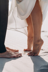 close-up of the legs of a woman and a man on the sand opposite each other