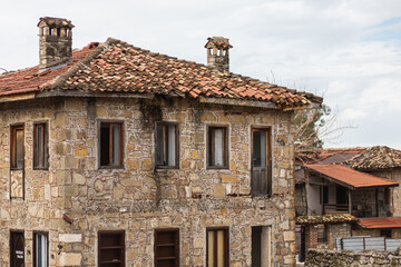 Close-up of an ancient destroyed stone building with a wooden  windows