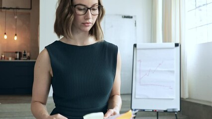 Young beautiful business woman at office walking confidently and smiling with a pile of papers and documents in hands towards her workspace and desktop at company.