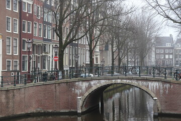 Fototapeta premium Amsterdam Leidsegracht Canal View with Stone Bridge, Parked Bicycles and House Facades, Netherlands
