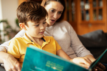 Mother and son reading a book. Little boy enjoy with mom reading a book..