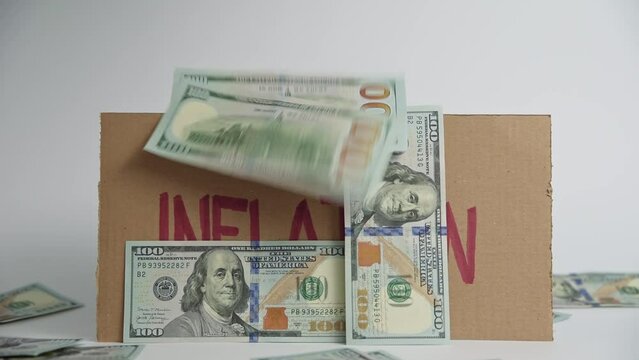 World economic crisis and inflation concept, Cardboard sheet with word inflation and falling us dollar banknotes, Rising prices for consumer goods and services