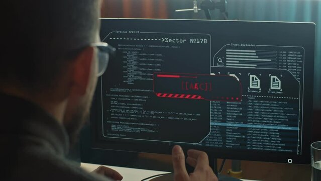 Close-up of computer hacker typing a code to break the server. Failing attempt of cyber crime in the company at night.