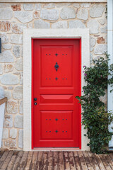 traditional white Greek house facade with red door