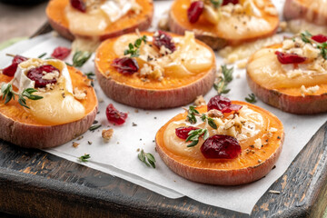 Baked Sweet Potato Rounds topped with brie cheese, cranberry and Walnut. Thanksgiving appetizer bites.