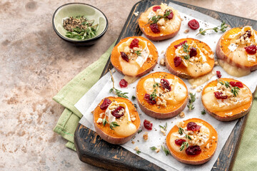 Baked Sweet Potato Rounds topped with brie cheese, cranberry and Walnut. Thanksgiving appetizer bites.