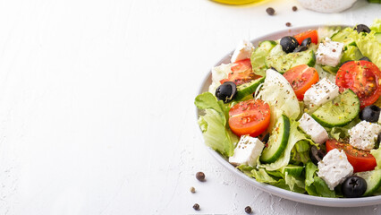 Healthy salad with cherry tomatoes, cucumber, lettuce and cheese. Diet food concept. Copy space