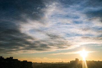 Morning sunrise over the city on a background of sky with clouds