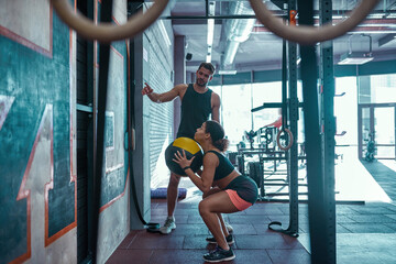 Trainer telling and looking at girl doing sit ups