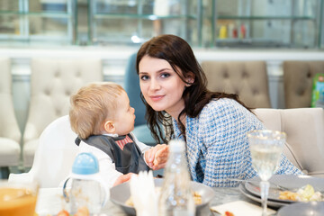 a beautiful dark-haired woman with a one-year-old boy at the banquet. 