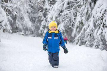 Sweet happy child, playing in deep snow