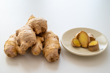 Ginger root and next to cut ginger on plate.
