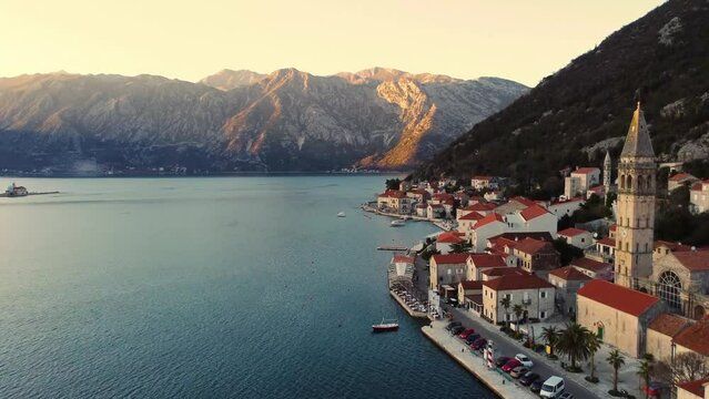 Panoramic sunset aerial drone view of the ancient city of Perast, Montenegro.Old medieval town with red roofs and with majestic mountains on background.Picturesque Kotor bay, coast of Adriatic sea.