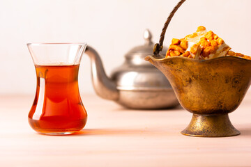 Black tea in armudu glass on wooden table