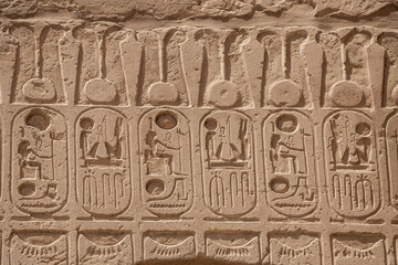 Ancient egyptian hieroglyphs carved on the stone wall in the Karnak Temple, Luxor, Egypt