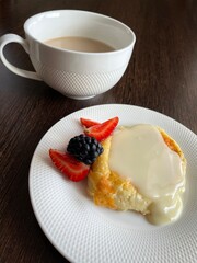 morning breakfast, homemade and healthy food, cottage cheese cakes with condensed milk and fresh strawberries and blackberries on a white porcelain saucer.