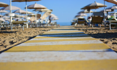 The walkway between the umbrellas and deck chairs that leads directly to the sea