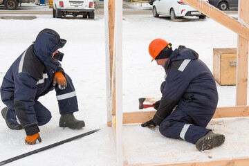 Workers on the installation of the frame of a wooden slide
