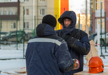 Two workers are talking at the assembly site of the ice town