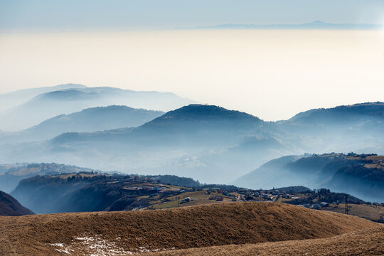 Winter landscape of the Lessinia plateau (Altopiano della Lessinia) and the Padana Plain or Po valley with fog. On horizont the mountain range of the Apennines. Erbezzo, Verona, Veneto, Italy, Europe.