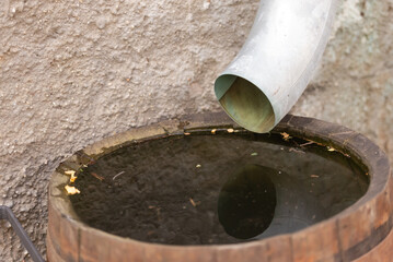 Drain pipe in a barrel. Drainage of rainwater not into the sewer, but into a wooden barrel. When there is no storm sewer.