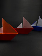 Multi colored origami sailing ship isolated on black background, Not Focus