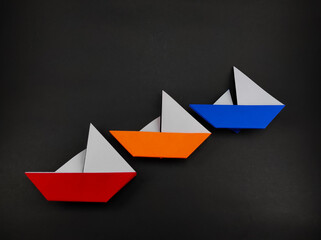 Multi colored origami sailing ship isolated on black background, Not Focus