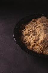 Homemade apple crumble with berries in low light. Dark food photo with copy space.